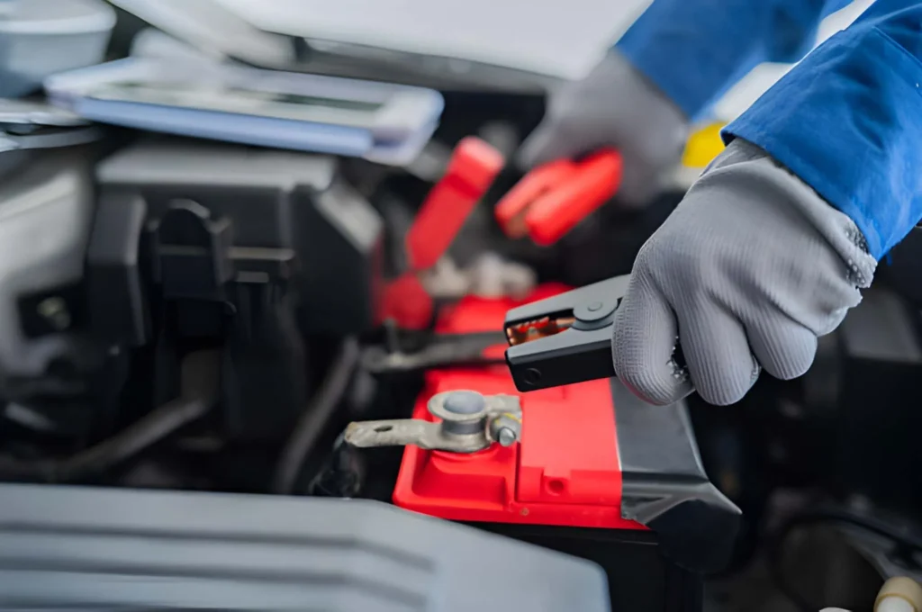 Car Jump Start Bros technician holding battery clamps for an emergency jump start in Leigh.