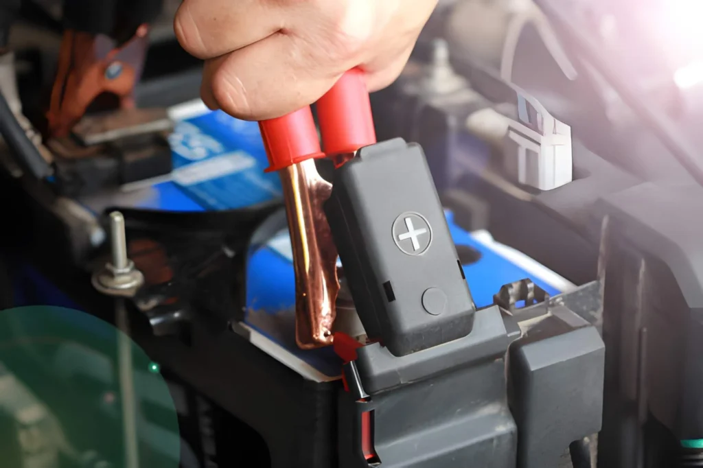 Close-up of a red clamp being attached to a battery terminal for a safe jump start in Farnworth.